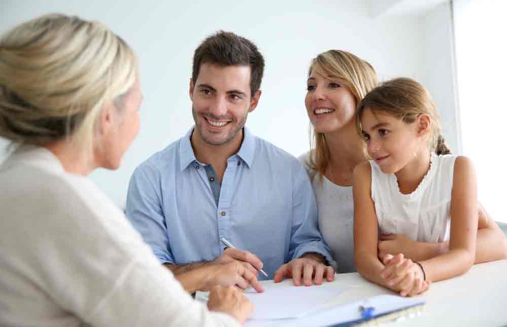 Couple signing contract with real estate agent Couple signing contract with real estate agent