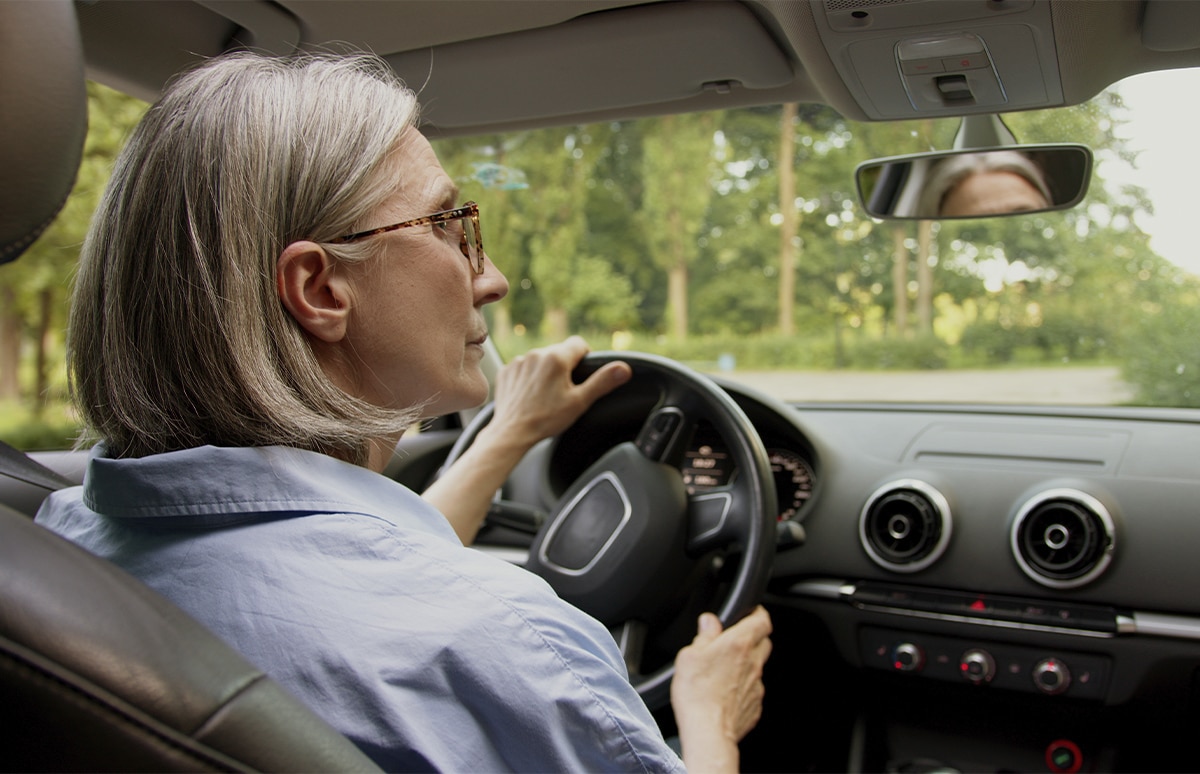 Mujer mayor conduciendo su automóvil