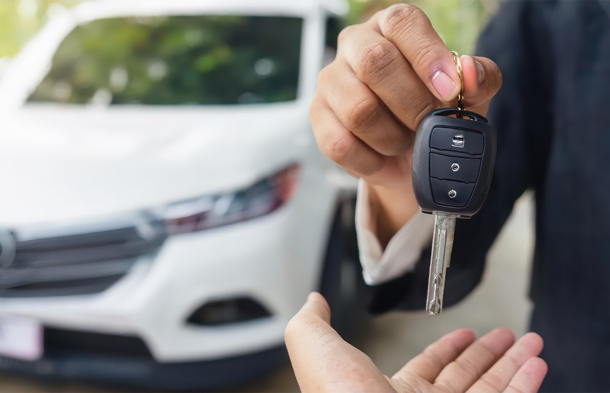 Comercial de un concesionario entregando las llaves de un coche de sustitución