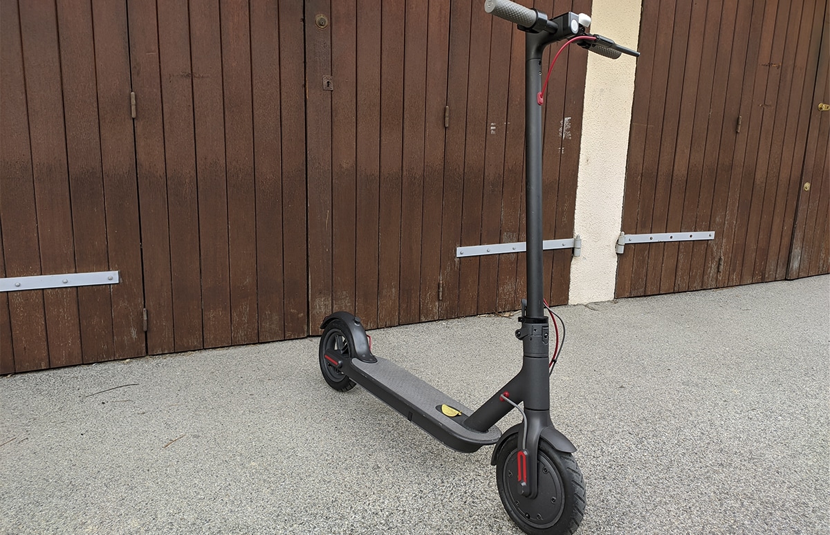 Patinete eléctrico Xiaomi delante de un trastero con las puertas de madera