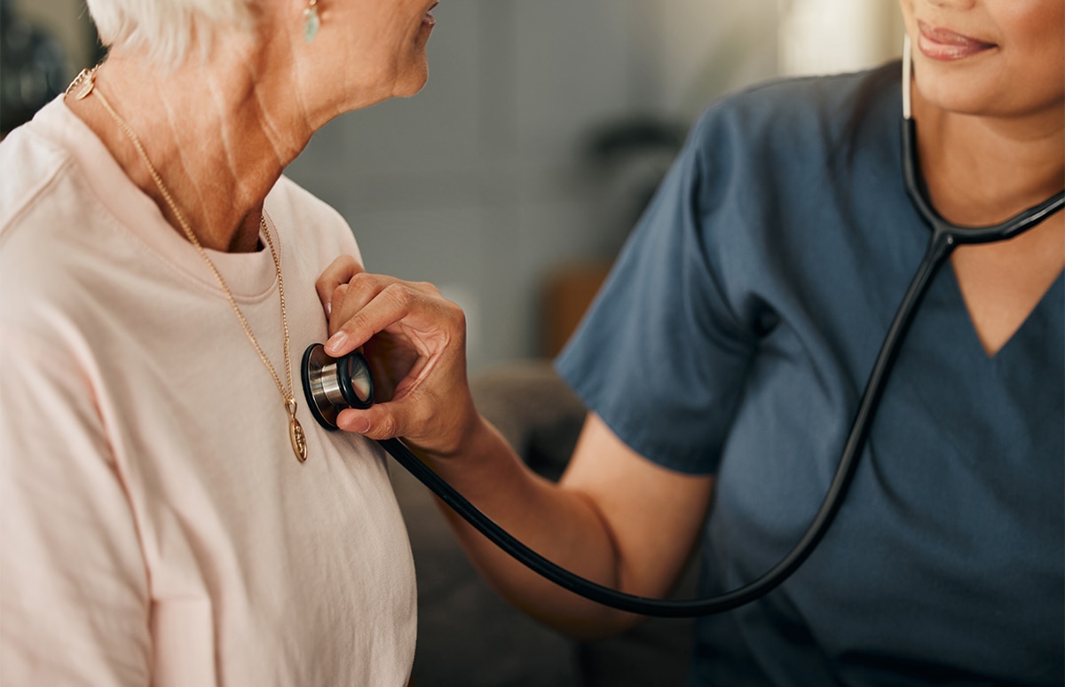 Doctora auscultando a una persona de avanzada edad