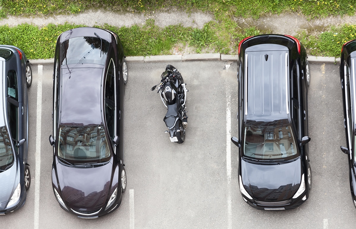 Moto estacionada en una plaza de aparcamiento para coche