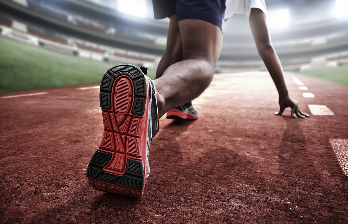 Primer plano de la zapatilla de un atleta antes de realizar la salida sobre un tartán