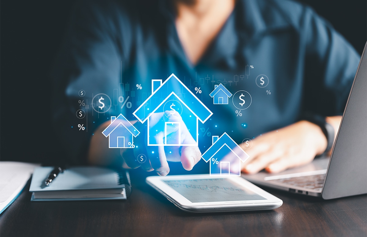 Mujer frente a un ordenador y una tablet realizando cálculos para el seguro de su vivienda