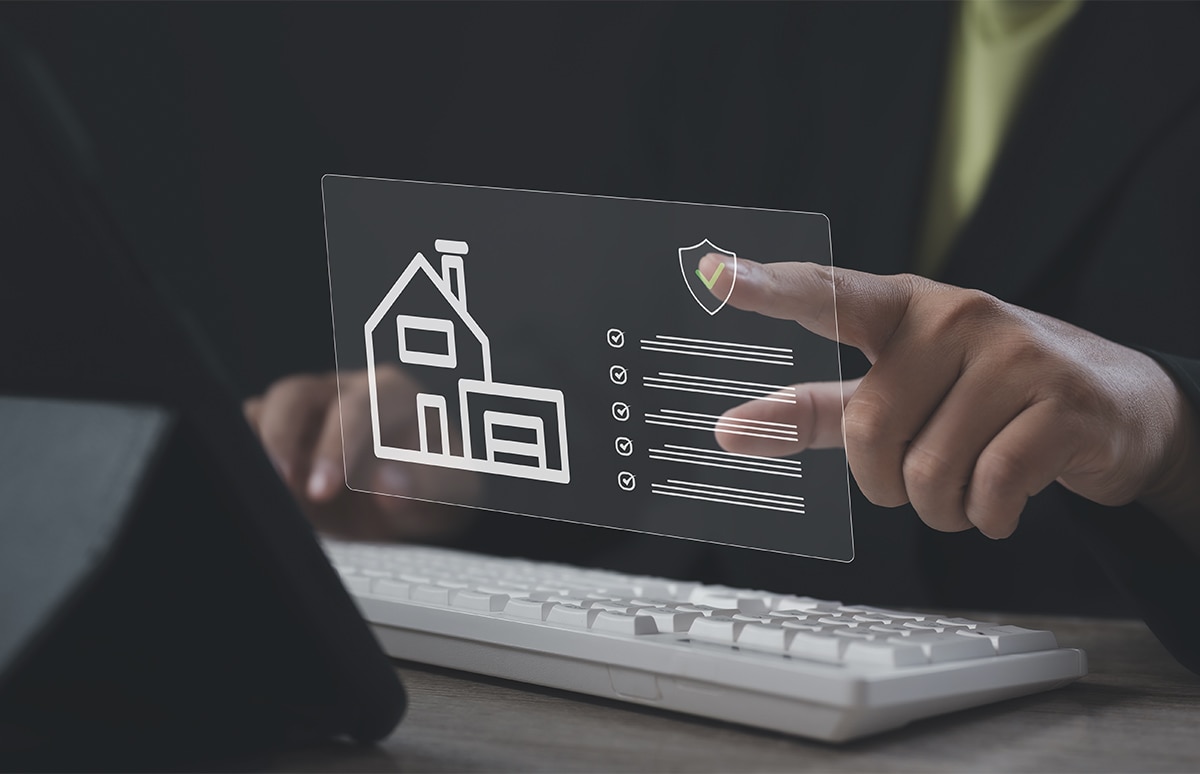 Manos de hombre sobre teclado de ordenador pulsando en documento de datos de una indemnización de hogar