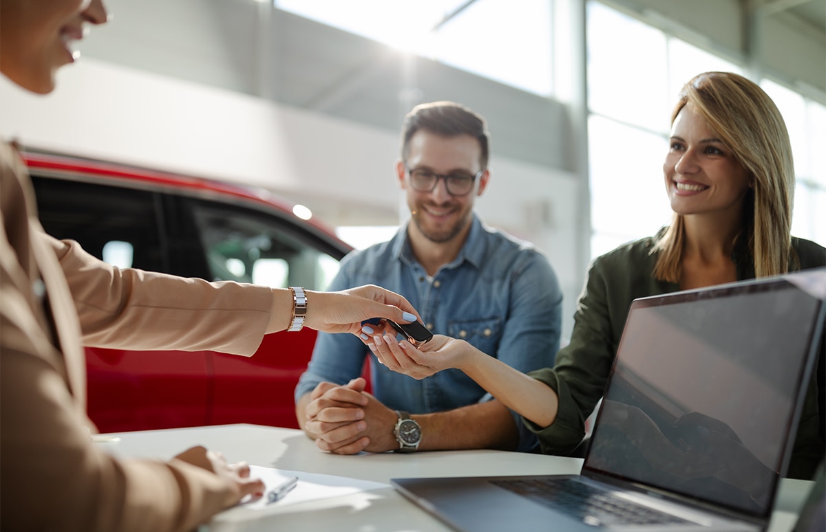 Agente dando la mano a un cliente en una venta de un coche