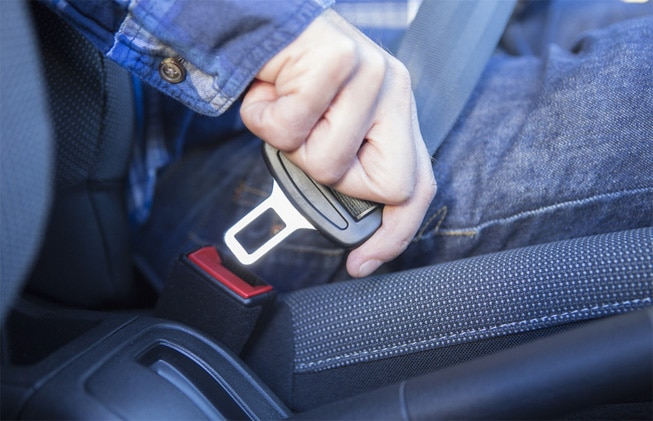 Close Up Of Person In Car Fastening Seat Belt