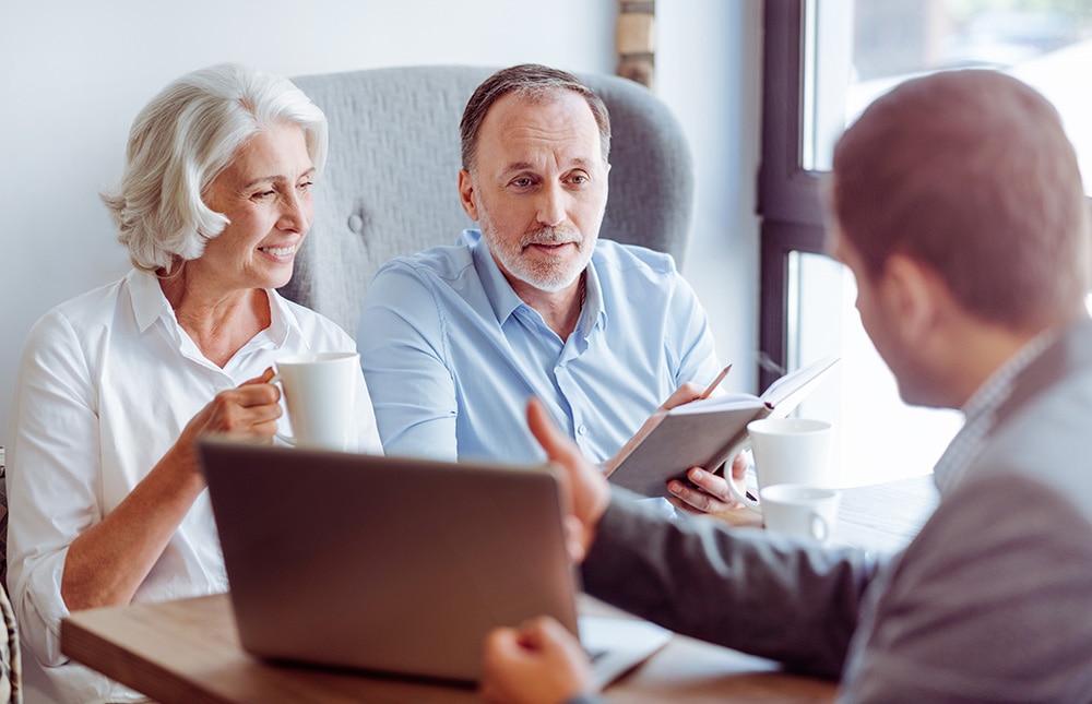 There are different options. Pleasant delighted aged couple sitting in the cafe and meeting with insurance agent while talking