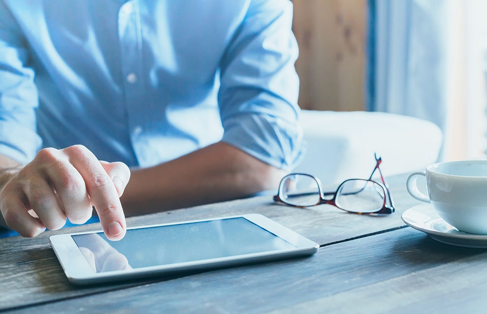 man using digital tablet computer, close up of the hand, business and technology background with copy space