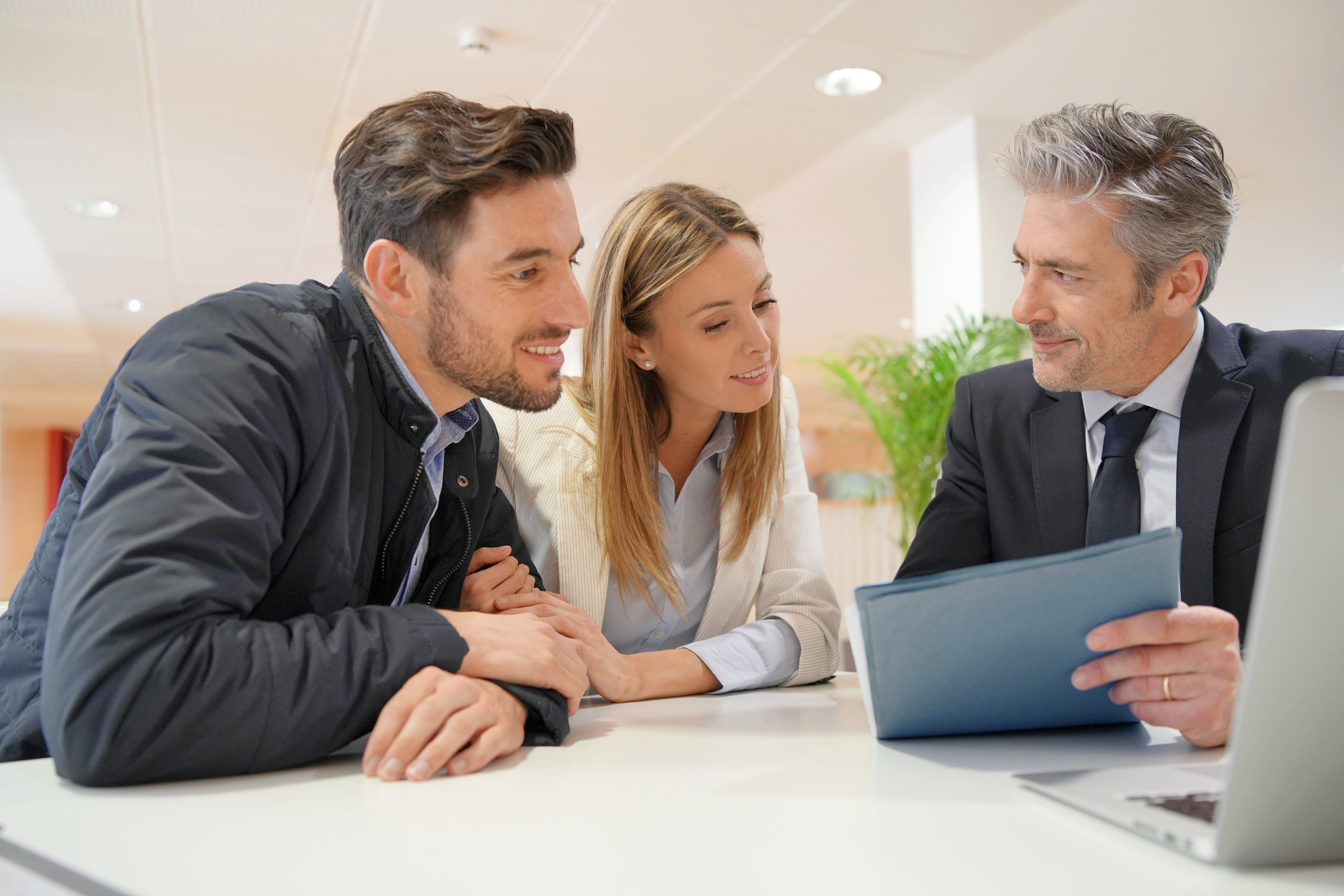 Couple signing contract with real estate agent