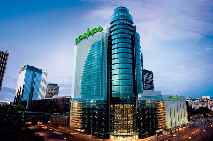 Edificio acristalado de gran altura con el logotipo verde de El Corte Inglés iluminado en la parte superior