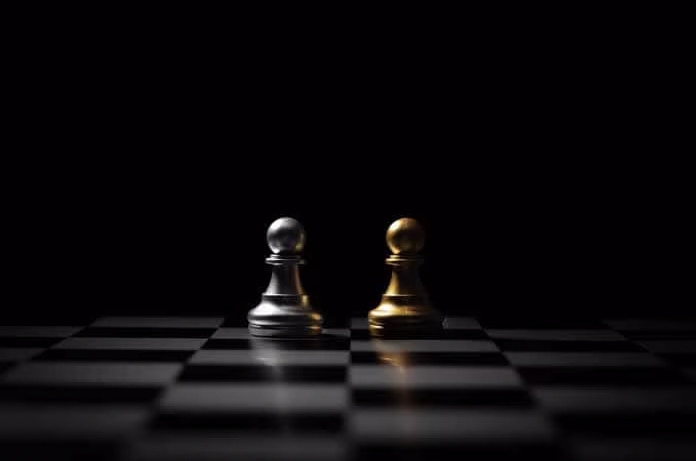 Dos peones de ajedrez, uno plateado y otro dorado