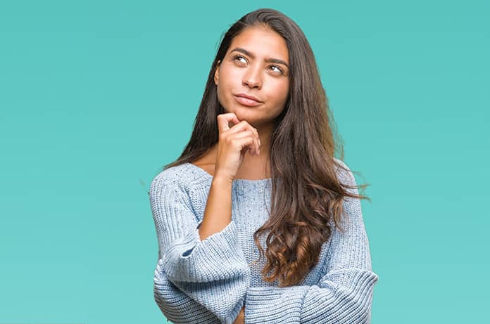 Persona en postura reflexiva con la mano en el mentón sobre un fondo verde agua