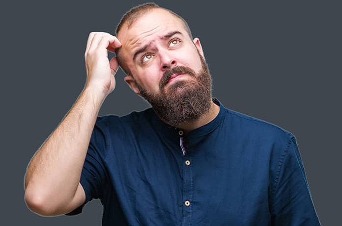 Persona rascándose la cabeza en un gesto de duda, sobre un fondo gris oscuro