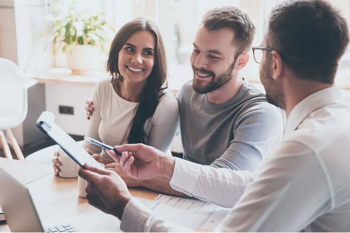 Couple signing contract with real estate agent