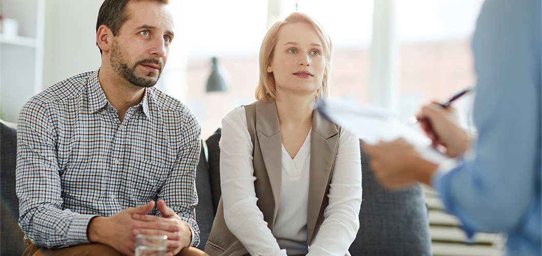 Couple signing contract with real estate agent