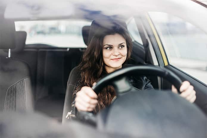 Mujer soriendo dentro del coche