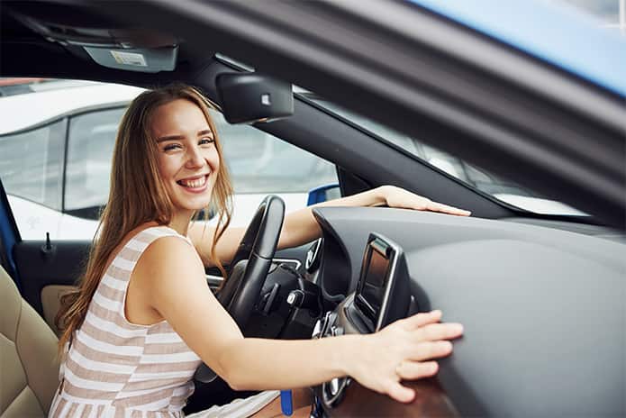 Mujer soriendo dentro del coche