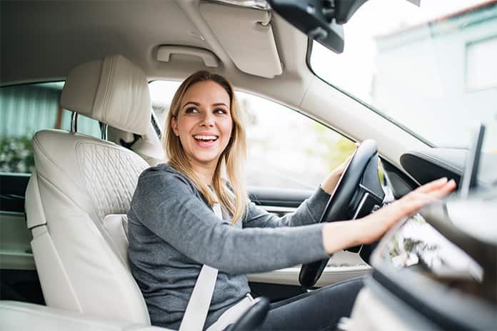 Mujer soriendo dentro del coche