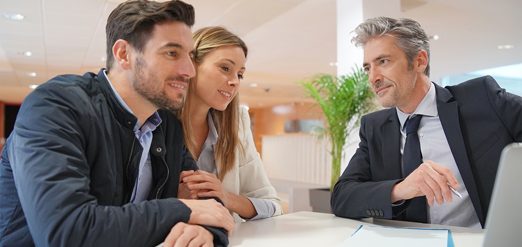 Couple signing contract with real estate agent