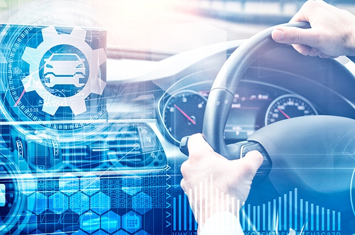 Manos sujetando un volante en un vehículo con gráficos digitales superpuestos relacionados con el automóvil