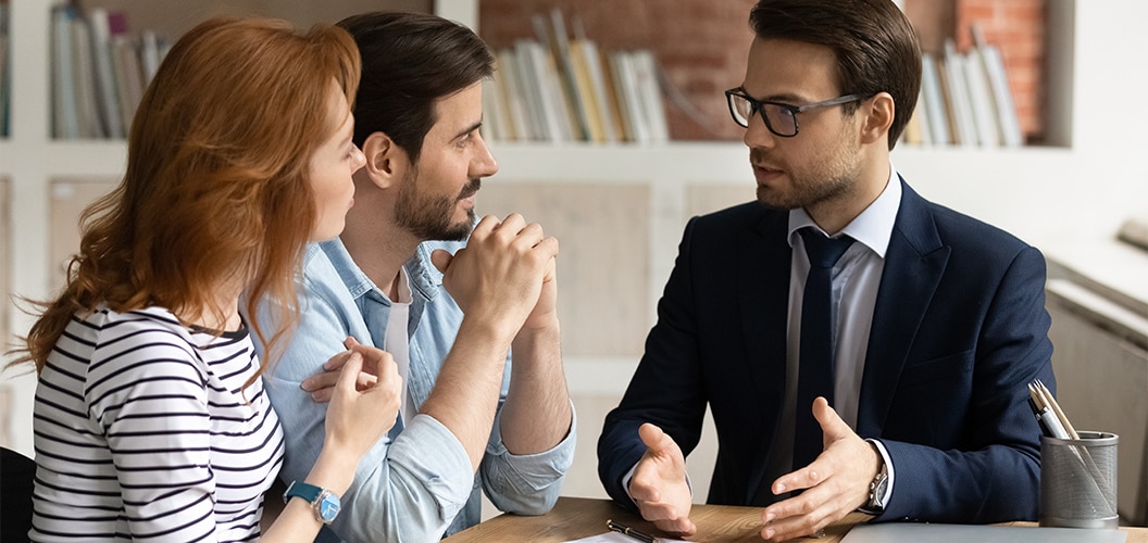 Grupo conversando alrededor de una mesa con libros y documentos durante una reunión en un entorno interior