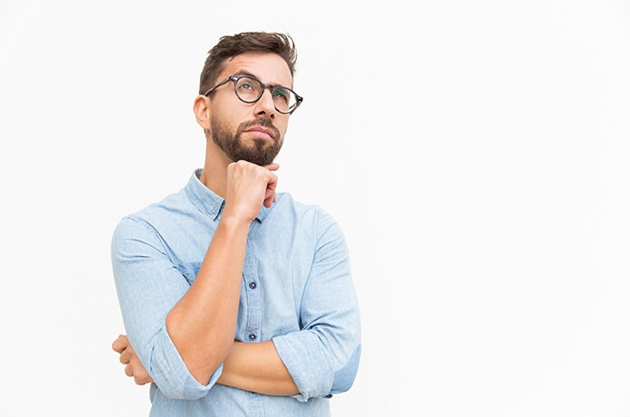 Figura con postura reflexiva, apoyando la mano en la barbilla y con los brazos cruzados, sobre un fondo blanco uniforme