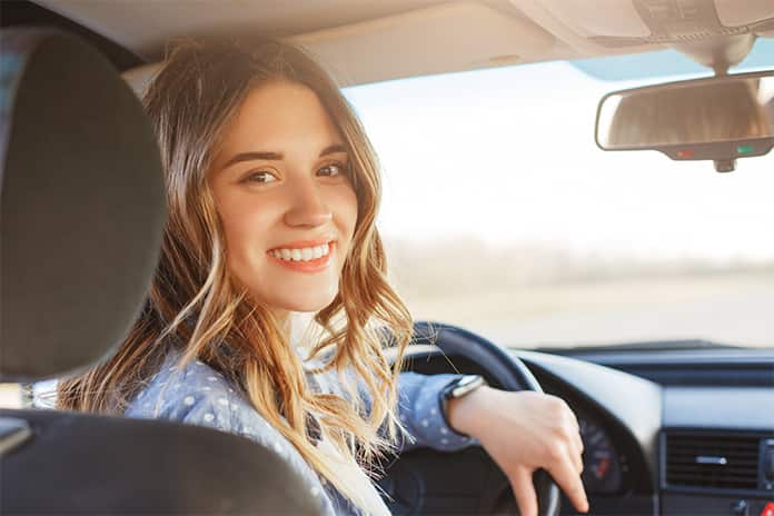 Mujer soriendo dentro del coche