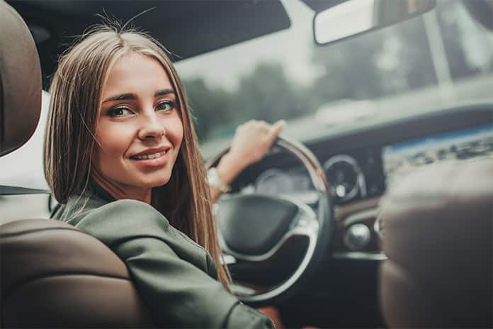 Mujer soriendo dentro del coche