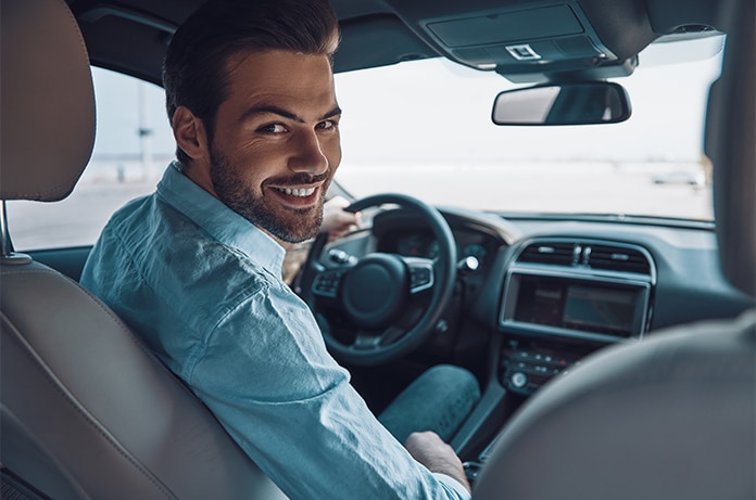 Vista del habitáculo delantero de un automóvil, con una persona sentada en el asiento del conductor y el salpicadero visible