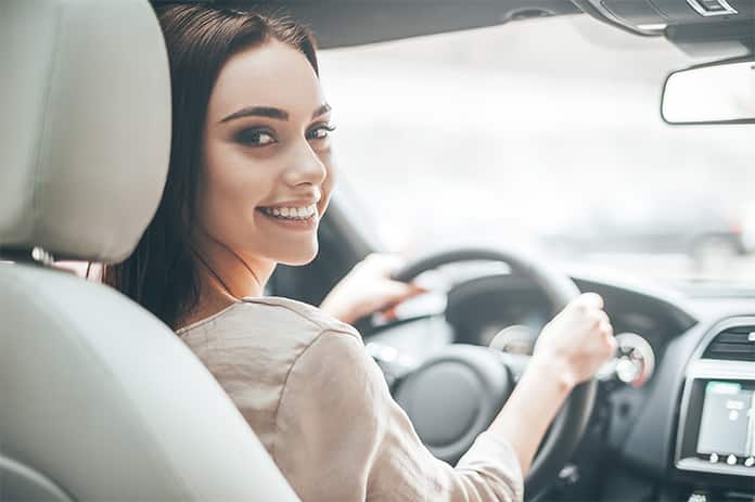 Mujer soriendo dentro del coche