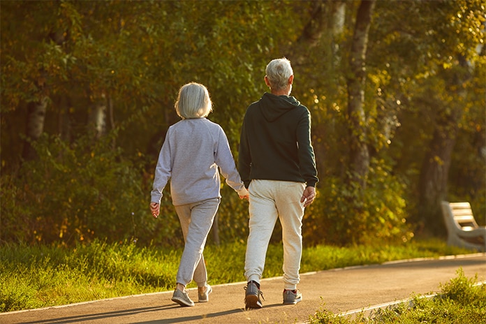 Dos personas mayores paseando al atardecer