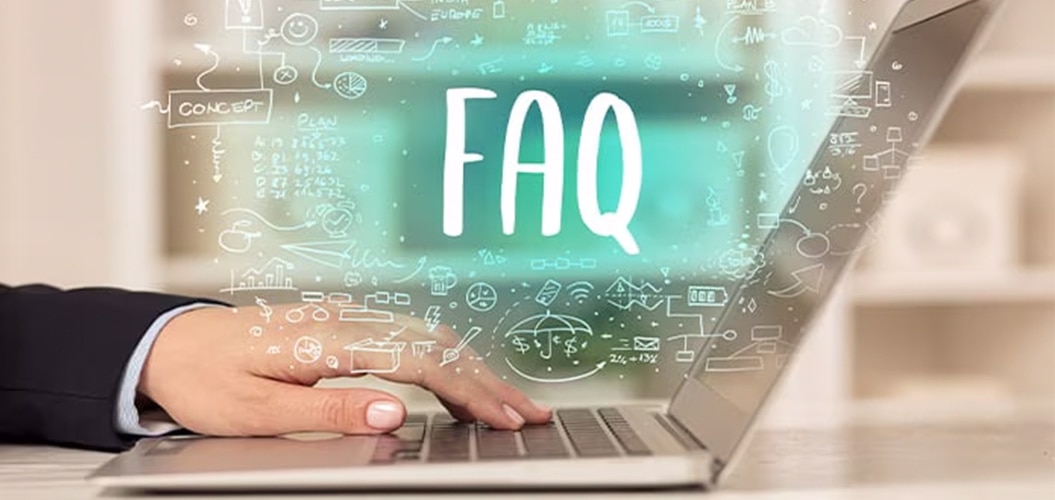 Mano utilizando un ordenador portátil con la palabra “FAQ” resaltada sobre iconos y gráficos digitales