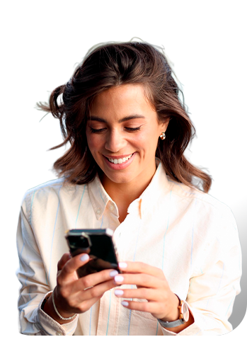 Persona sosteniendo un teléfono móvil con ambas manos sobre un fondo blanco, vistiendo una camisa clara y accesorios visibles en las muñecas