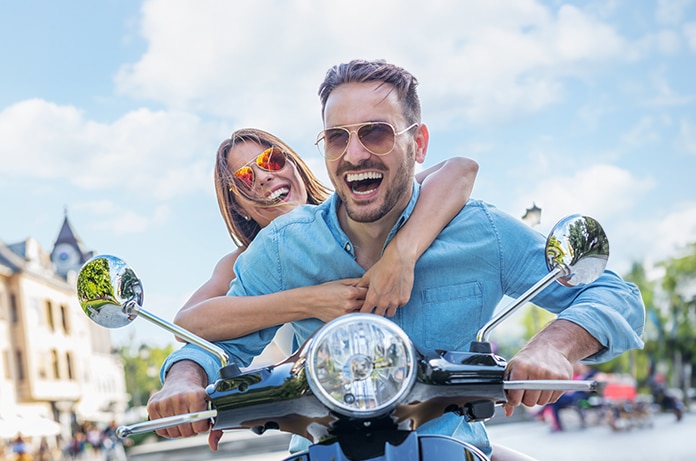 Pareja divirtiéndose sobre una motocicleta