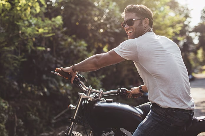 Persona sentada sobre una motocicleta en un entorno natural mientras sujeta el manillar