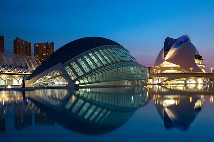 Complejo arquitectónico moderno de la Ciudad de las Artes y las Ciencias de Valencia reflejado sobre una superficie de agua al anochecer