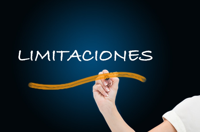 Mano escribiendo la palabra “LIMITACIONES” en una pizarra oscura con un trazo curvo en color naranja