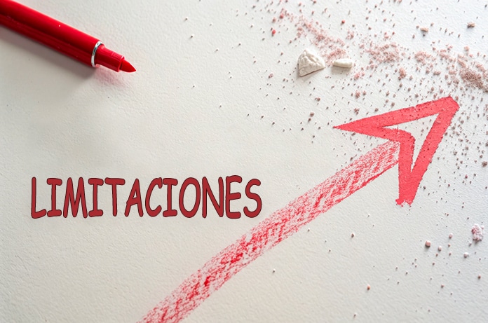Flecha roja dibujada en diagonal ascendente sobre una superficie clara, junto a la palabra “LIMITACIONES” escrita en rojo y restos de lápiz o pigmento esparcidos alrededor