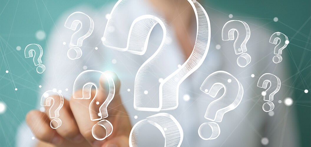 Mano señalando un icono transparente de signo de interrogación entre varios símbolos similares sobre un fondo desenfocado