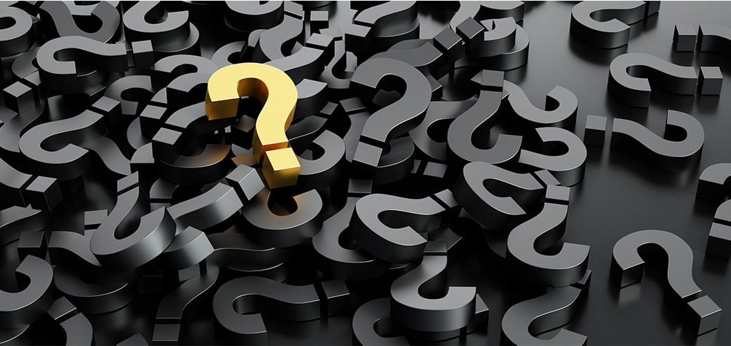 Signo de interrogación dorado destacado entre numerosos signos de interrogación negros dispersos sobre una superficie