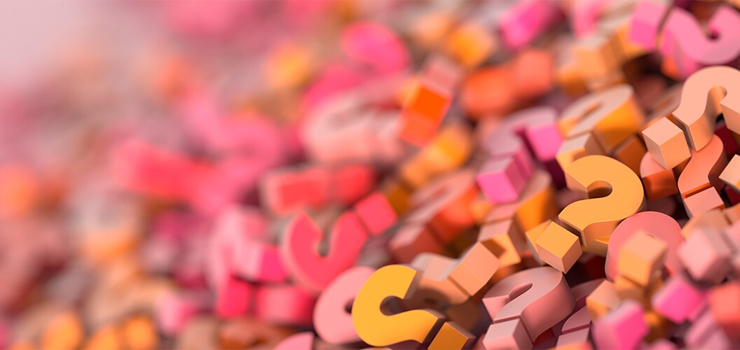 Superficie cubierta por numerosos signos de interrogación en tonos rosados, naranjas y amarillos, creando un patrón caótico y vibrante