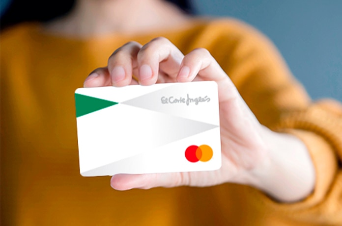 Mano sosteniendo una tarjeta de El Corte Inglés en primer plano sobre un fondo desenfocado